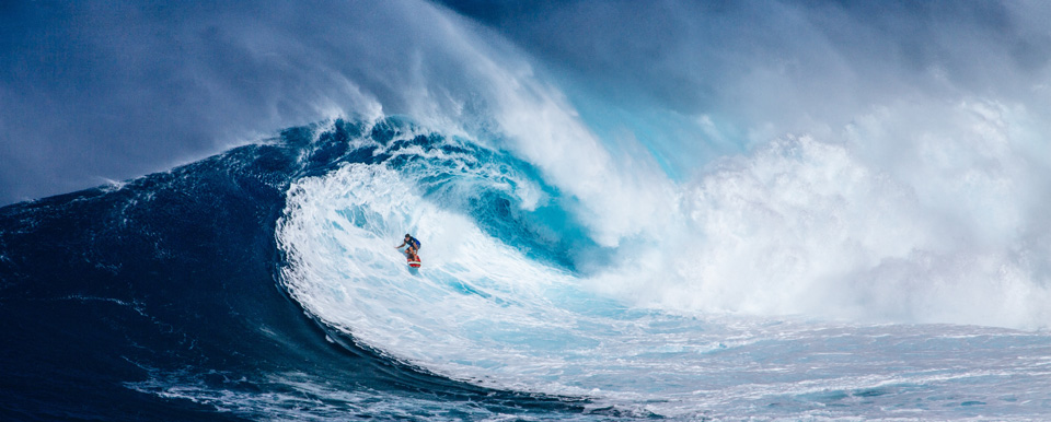 Wellenreiter auf großer blauer Welle
